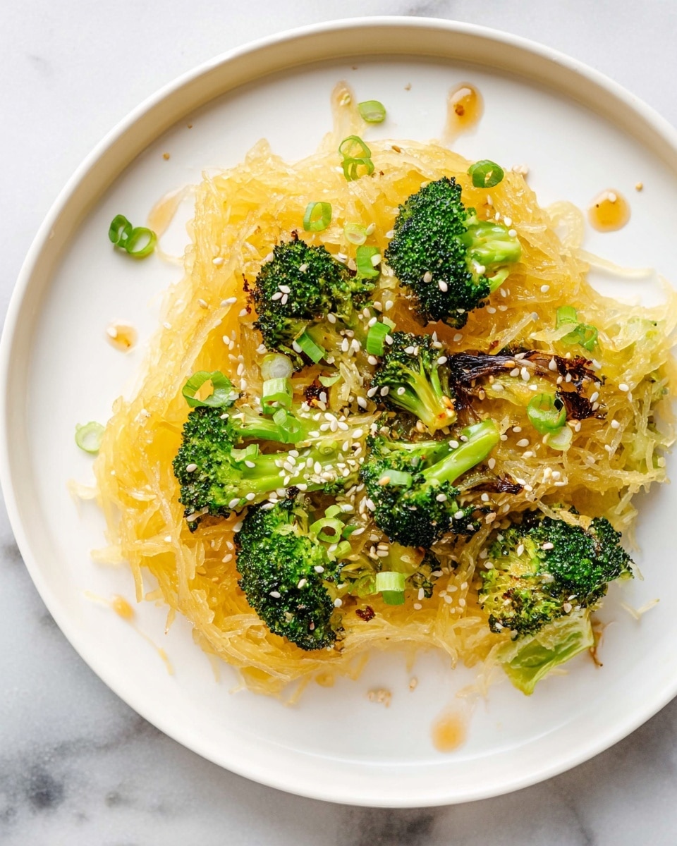 The image shows a white plate with a serving of cooked spaghetti squash as the base layer, light yellow in color with a slight sheen from sauce. On top, there are bright green broccoli florets with some parts roasted to a dark brown. Scattered throughout are white sesame seeds and small pieces of light green scallions adding texture. Around the plate's edge, there are small drops of sauce on the white marbled surface beneath the plate, enhancing the dish's fresh and vibrant look. Photo taken with an iphone --ar 4:5 --v 7