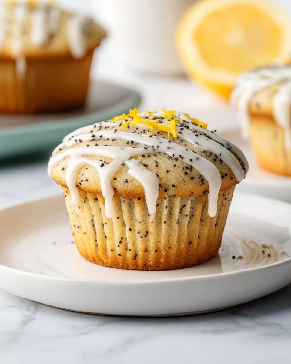 The image shows a single lemon poppy seed muffin placed on a white plate with a smooth surface. The muffin has a light golden color with small dark poppy seeds spread evenly throughout. On top, there is a layer of white glaze drizzled in thick lines, with some glaze dripping slightly down the sides. Small pieces of yellow lemon zest and black poppy seeds are scattered on the glaze as decoration. The background features a white marbled texture with a slice of lemon slightly blurred in the distance, and a second muffin is partially visible on the right side. The photo taken with an iphone --ar 4:5 --v 7