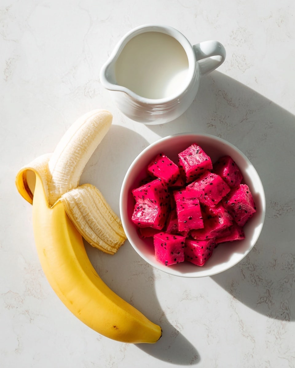 The image shows three main elements on a white marbled surface: an opened peeled yellow banana on the left, a small white pitcher filled with white milk at the top right, and a white bowl filled with bright pink, cubed dragon fruit pieces placed at the bottom right. The peeled banana has smooth, soft texture visible and its peel curves outward. The cubed dragon fruit pieces look fresh with small black seeds visible in some cubes. The white pitcher has a smooth glaze and a handle, with milk inside visible from above. The overall setup is simple and clean with a bright natural light casting soft shadows. photo taken with an iphone --ar 4:5 --v 7