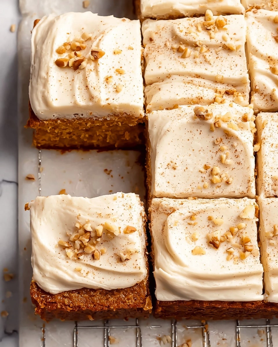 The image shows a square cake cut into six pieces, placed on a white marbled surface with a metal rack underneath. The cake has two clear layers: the bottom layer is a light brown, moist textured cake, while the top layer is a smooth, white creamy frosting. The frosting is evenly spread but has soft swirled patterns and is sprinkled with small chopped nuts and a light dusting of brown spice. The cake edges are well-defined, and the overall look is neat and inviting. Photo taken with an iphone --ar 4:5 --v 7